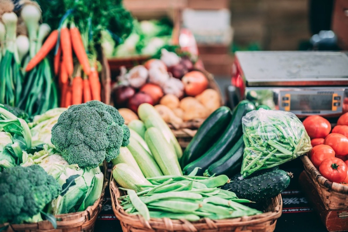 Kist met verse groenten en fruit: sla, appels, druiven, broccoli en wortels
